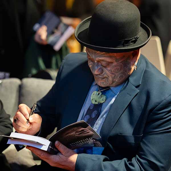 Dr Ngaropo signing copies of his new biography at the launch.