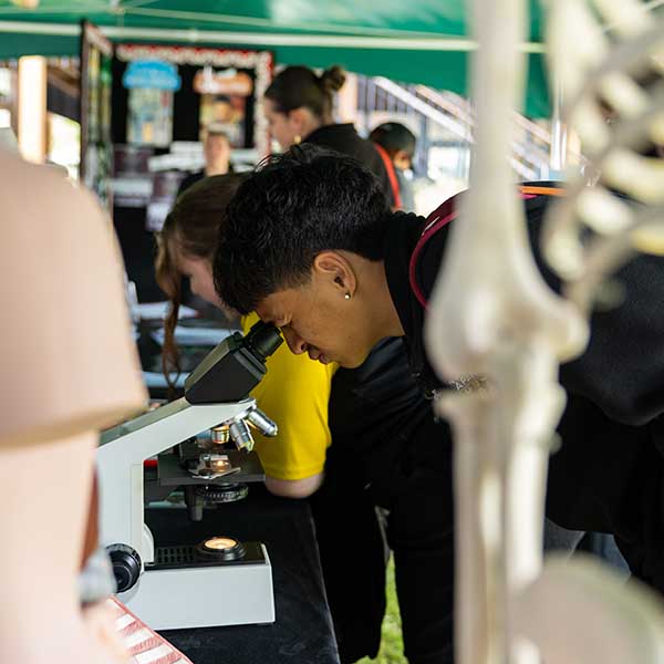 student looks through microscope